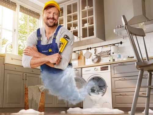 Handwerker mit Rohrzange erscheint aus auslaufender Wachmaschine